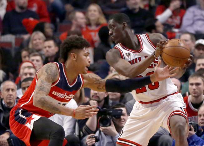 Washington Wizards forward Kelly Oubre Jr., left, knocks the ball loose from Chicago Bulls forward Tony Snell during the first half of an NBA basketball game, Monday, Jan. 11, 2016, in Chicago.
