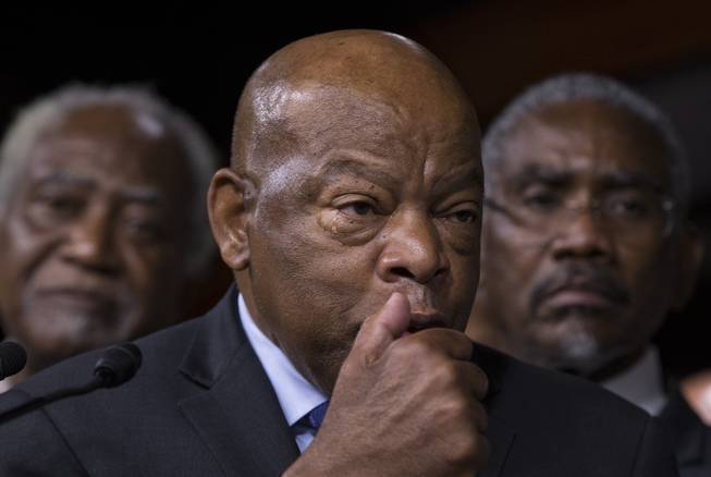 Civil right leader Rep. John Lewis, D-Ga., sheds a tear as he pauses during a news conference with members of the Congressional Black Caucus, on Capitol Hill in Washington, Friday, July 8, 2016, to condemn the the fatal police shootings of black men in Louisiana and Minnesota earlier in the week. At rear are Rep. Danny K. Davis, D-Ill., left, and Rep. Gregory W. Meeks, D-N.Y. (AP Photo/J. Scott Applewhite)