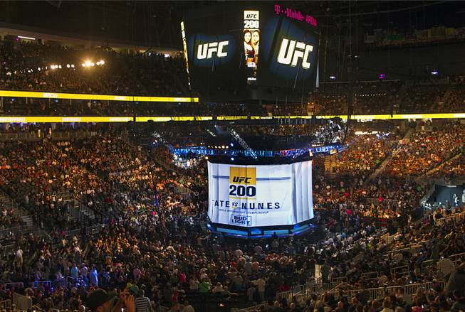 Fans come to their feet as a drape covers the octagon on Saturday July 9, at the start of the UFC 200 pay-per-view card at T-Mobile Arena.