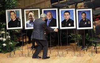 Portraits of five fallen officers are arranged prior to a memorial service at the Morton H. Meyerson Symphony Center, Tuesday, July 12, 2016, in Dallas. Five police officers were killed and several injured during a shooting in downtown Dallas last Thursday night. (AP Photo/Eric Gay)