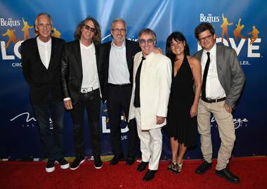 Cirque du Soleil CEO Daniel Lamarre, in white suit, appears with others at a red carpet event for the Beatles “Love” 10th anniversary celebration, Thursday, July 15, 2016.
