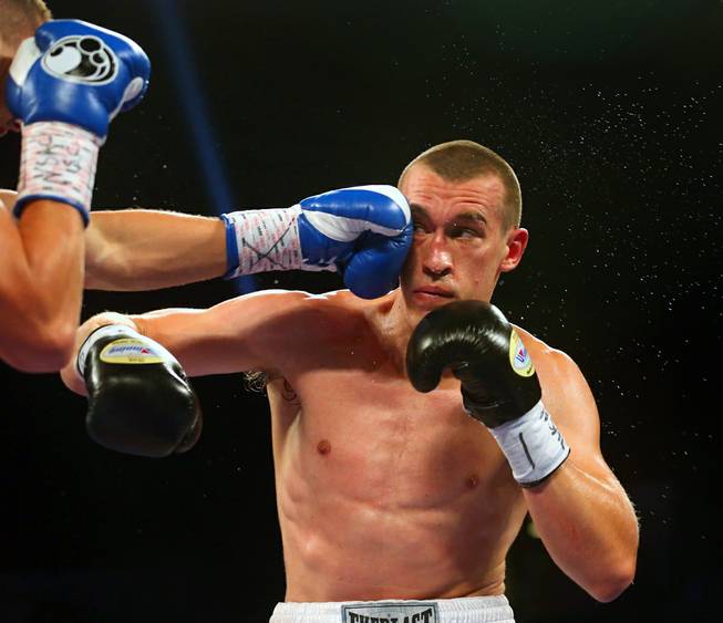 Tommy Karpency takes a punch from opponent Oleksandr Gvozdyk during their light heavyweight fight at the MGM Grand Garden Arena on Saturday, July 23, 2016.