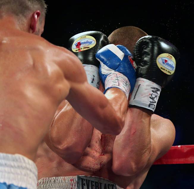 Oleksandr Gvozdyk, left, finds an opening between the gloves of Tommy Karpency, breaking his nose, during their light heavyweight fight at the MGM Grand Garden Arena on Saturday, July 23, 2016.