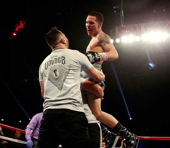 Featherweight boxer Oscar Valdez leaps into the arms of his team as he celebrates his win over Matias Rueda during the fight at the MGM Grand Garden Arena on Saturday, July 23, 2016.