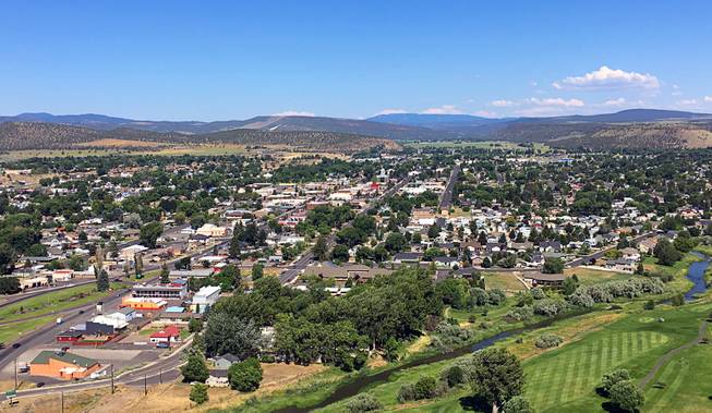 In this June 29, 2016 photo, the town of Prineville, Ore., is seen with the Ochoco National Forest on the horizon. When timber was king, Crook County was the nation's top producer of ponderosa lumber. But with the catastrophic decline in the timber industry, and the global recession after that, suddenly the digital revolution is providing the county and its main town, Prineville, with a rare second chance. 