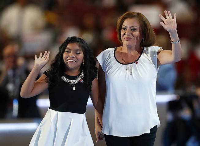 Karla Ortiz, 11, left, and mother, Francisca Ortiz, wave after speaking during the first day of the Democratic National Convention in Philadelphia, Monday, July 25, 2016. 