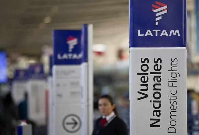 An agent of LATAM airlines stands by the counters at the airport in Santiago, Chile, Monday, July 25, 2016. LATAM airlines created in 2012 after a fusion between the airlines LAN of Chile and TAM of Brazil, has agreed to pay more than $22 million in fines related with a scheme to bribe Argentine union officials via a false consulting contract. The airline will pay the fine to the Securities and Exchange Commission (SEC) and the Department of Justice (DOJ) for a violation of the accounting provisions of the Foreign Corrupt Practices Act. 
