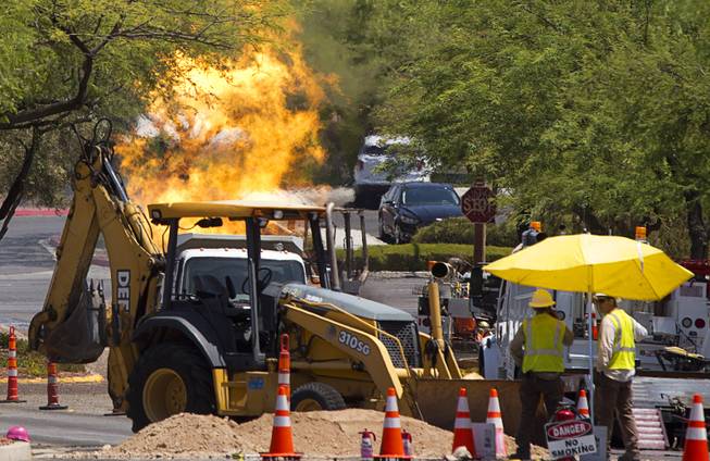 Officials monitor a natural gas fire in a residential neighborhood in Summerlin Tuesday, July 26, 2016. The fire was apparently started when backhoe hit a natural gas line during construction.
