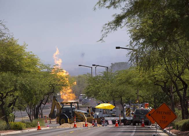 Officials monitor a natural gas fire in a residential neighborhood in Summerlin Tuesday, July 26, 2016. The fire was apparently started when backhoe hit a natural gas line during construction.