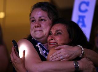 Alpha Lillstrom and Nadia Halma cry as Democratic Presidential candidate Hillary Clinton appears on the screen during the second day session of the Democratic National Convention in Philadelphia, Tuesday, July 26, 2016. (AP Photo/John Locher)