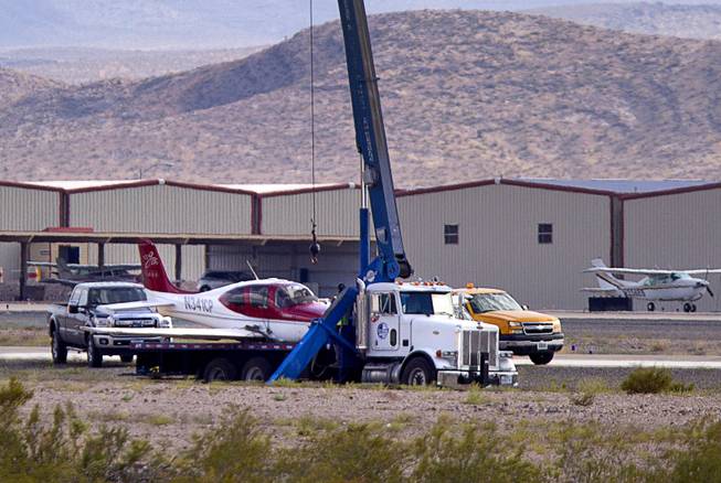 A small plane is shown on a flatbed after crash-landing short of the runway at the Henderson Executive Airport in Henderson Thursday, July 28, 2016. No one was injured in the accident, officials said. 
