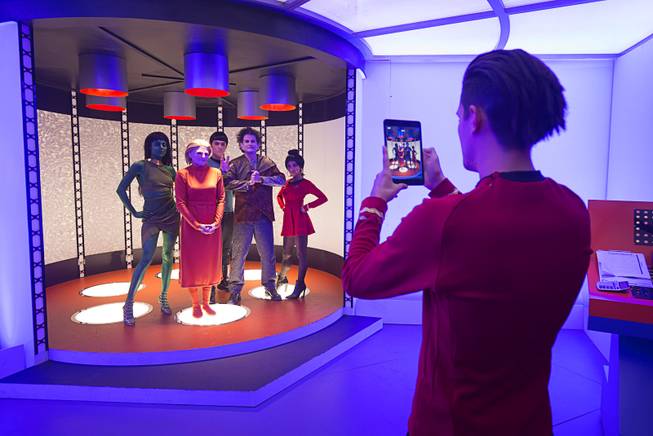 Jacquii DeMatteis and her husband David of Temecula, Calif. pose with actors in a mock-up of a transporter room at the MAC cosmetics booth during the final day of Creation Entertainment's annual Official Star Trek convention at the Rio Sunday, August 7, 2016. The booth provided a free video that shows the participant disappearing and reappearing.