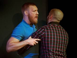 Welterweight Conor McGregor is restrained while yelling back at Nate Diaz as the two argued ending the UFC 202 press conference within the David Copperfield Theater in the MGM Grand on Wednesday, August 17, 2016.