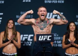 Welterweight Conor McGregor flexes and yells on the scale as he readies to face opponent Nate Diaz during the UFC 202 weigh-ins at the MGM Grand on Friday, August 19, 2016.