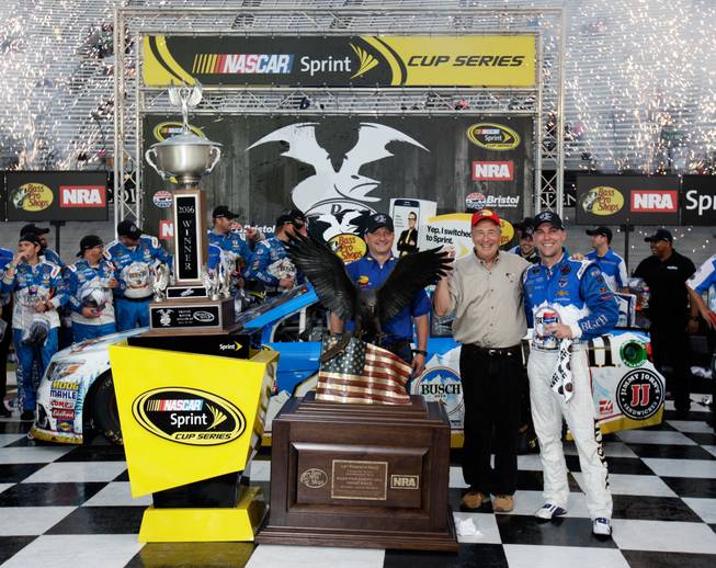 Kevin Harvick, right, celebrates Sunday, Aug. 21, 2016, after winning a NASCAR Sprint Cup Series auto race with Bass Pro Shops founder John Morris, center, and Jeff Hall, manager of Bass Pro Shops of Bristol, in Bristol, Tenn. The race was delayed Saturday night due to severe weather.