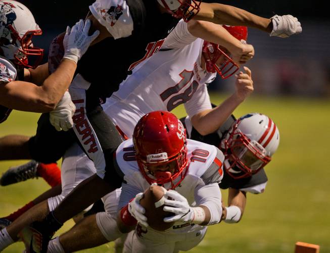 Arbor View's Dekarri Gunn (10) dives for a touchdown over the goal line against Liberty defenders during their season opener on Friday, August 26, 2016.