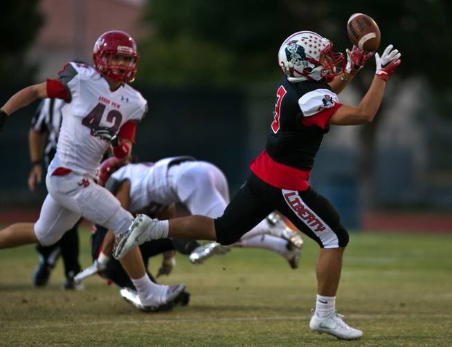Liberty's Joshua Zepeda (3) secures a tipped pass for long yards over Arbor View's  Andrew Wagner (42) during their season opener on Friday, August 26, 2016.