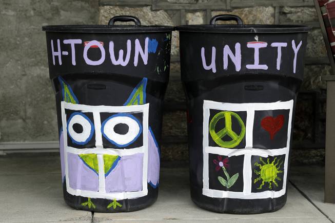 This Thursday, Aug. 25, 2016 photo, shows Megan Connell's trashcan that she painted to show support for her neighbor who's trashcan were defaced with a large swastika in Havertown, Pa. Esther Cohen-Eskin's painted a flower over the swastika on her garbage can and her neighborhood has rallied around the Jewish family by painting their trashcans in support. 