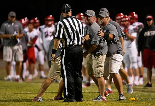 Arbor View head coach Dan Barnson loses control with a referee and is held back by assistants following a late-game call that negates their touchdown during their season opener on Friday, August 26, 2016.