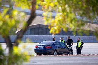 Nevada Highway Patrol troopers confer by a Toyota Camry as they investigate a fatal auto-pedestrian accident on Interstate 15 southbound between Spring Mountain and Flamingo roads Sunday morning, Aug. 28, 2016.