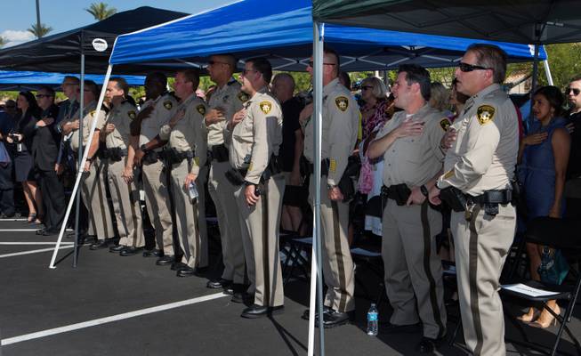 Officers and invited guests stand for the Pledge of Allegiance during the opening ceremonies for the Spring Valley Area Command to service a portion of the western valley on Tuesday, August 30, 2016.