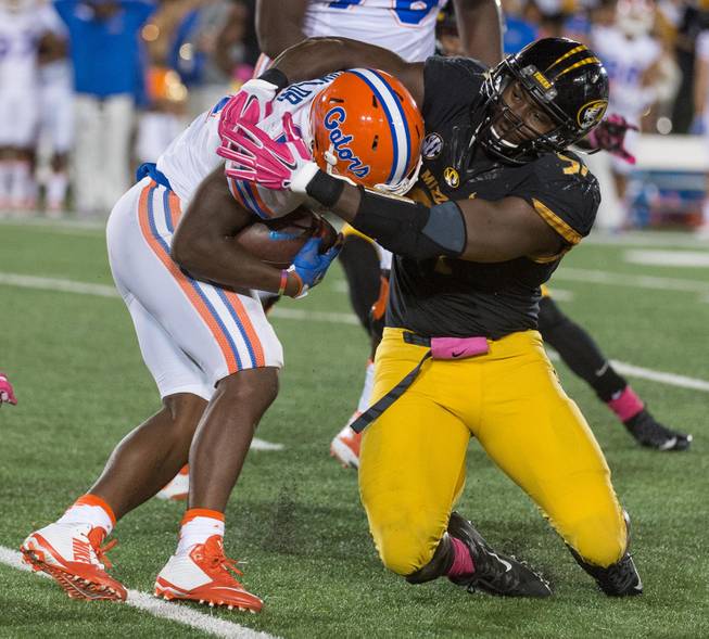Florida running back Kelvin Taylor, left, is tackled by Missouri's Charles Harris, right, during the first half of an NCAA college football game, Saturday, Oct. 10 2015, in Columbia, Mo.  