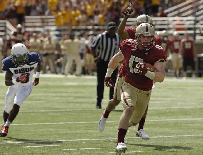 Boston College linebacker Connor Strachan (13) takes a pass interception into the end zone for a touchdown during the first half of their NCAA college football game as Howard wide receiver Robert Mercer (8) pursues Saturday, Sept. 12, 2015, in Boston. 