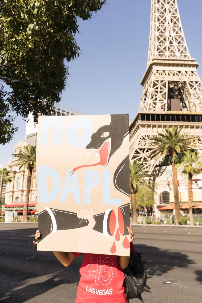A protestor holds up a sign during the "We Stand with Standing Rock" protest in support of the Standing Rock Sioux tribe, in front of the Bellagio Casino, Friday, Sept. 9, 2016. The Standing Rock Sioux tribe is fighting to stop the Dakota Access Pipeline (DAPL) from passing through their lands in North Dakota, which they say will contaminate the water and violate sacred grounds.