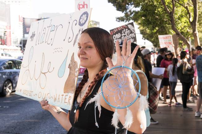 Larissa Brandon holds a dream catcher and sign during the "We Stand with Standing Rock" protest in support of the Standing Rock Sioux tribe, in front of the Bellagio Casino, Friday, Sept. 9, 2016. The Standing Rock Sioux tribe is fighting to stop the Dakota Access Pipeline (DAPL) from passing through their lands in North Dakota, which they say will contaminate the water and violate sacred grounds.