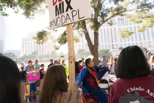 Protestors look on as Amaia Marcos performs a dance during the "We Stand with Standing Rock" protest in support of the Standing Rock Sioux tribe, in front of the Bellagio Casino, Friday, Sept. 9, 2016. The Standing Rock Sioux tribe is fighting to stop the Dakota Access Pipeline (DAPL) from passing through their lands in North Dakota, which they say will contaminate the water and violate sacred grounds.