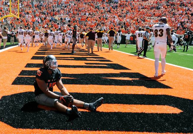 Oklahoma State linebacker Chad Whitener sits alone in the Central Michigan end zone while the Central Michigan team celebrates a last second touchdown by wide receiver Corey Willis, resulting in a 30-27 win over Oklahoma State following an NCAA college football game in Stillwater, Okla., Saturday, Sept. 10, 2016.