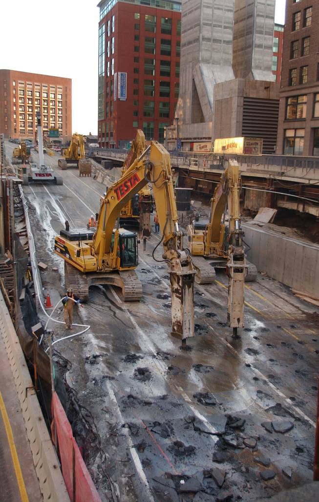 Demolition cranes work their way down the old elevated Southeast Expressway Monday morning, Dec. 22, 2003, in downtown Boston. The new depressed highway opened Saturday. 