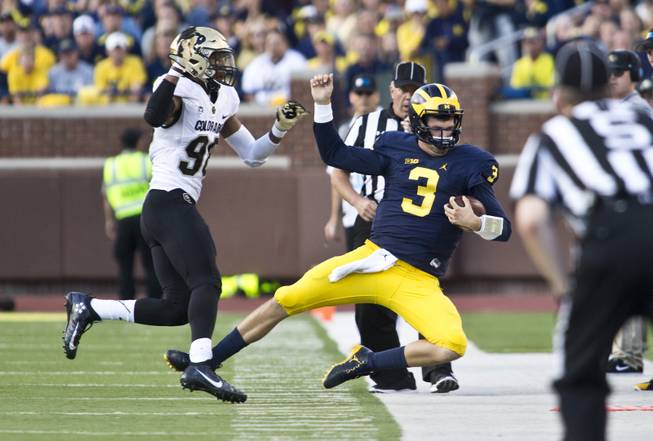 Colorado outside linebacker Jimmie Gilbert (98) pushes Michigan quarterback Wilton Speight (3) out of bounds on a carry in the fourth quarter of an NCAA college football game at Michigan Stadium in Ann Arbor, Mich., Saturday, Sept. 17, 2016. Michigan won 45-28. 