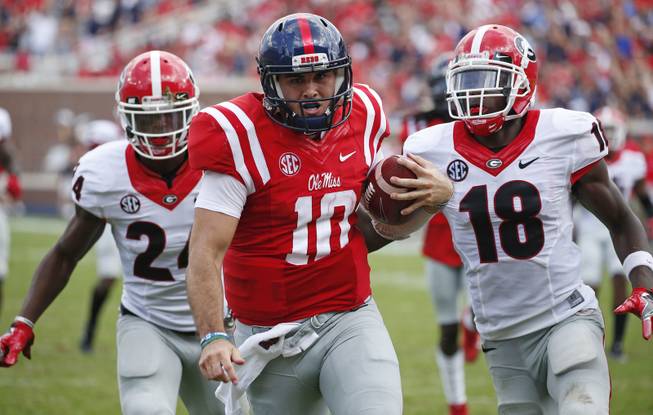 Mississippi quarterback Chad Kelly (10) runs past Georgia cornerback Deandre Baker (18) and safety Dominick Sanders (24) for a 41-yard touchdown run during the second half of their NCAA college football game, Saturday, Sept. 24, 2016, in Oxford, Miss. No. 23 Mississippi won 45-14. 