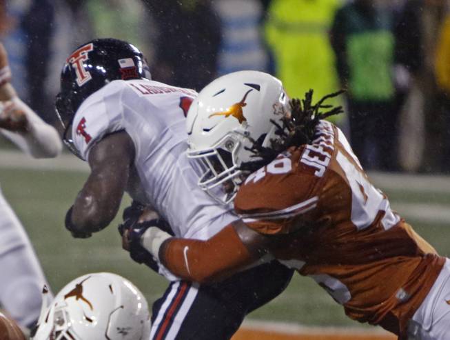 Texas linebacker Malik Jefferson, right, tackles Texas Tech running back Devin Lauderdale, left, and caused a fumble during the first half of an NCAA college football game, Thursday, Nov. 26, 2015, in Austin, Texas. 