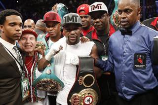 Floyd Mayweather Jr., center, stands with referee Kenny Bayless, right, after defeating Andre Berto during their welterweight title boxing bout Saturday, Sept. 12, 2015, in Las Vegas.