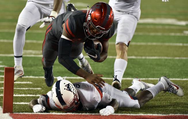 Houston quarterback Greg Ward Jr., top, leaps over Connecticut cornerback Jamar Summers to score a 10-yard touchdown in the second half of an NCAA college football game, Thursday, Sept. 29, 2016, in Houston. 