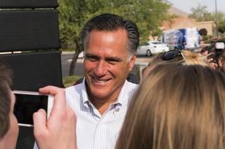 Former Massachusetts governor Mitt Romney poses for a photo with a supporter during a get-out-the-vote rally at Congressman Cresent Hardy's headquarters in Las Vegas, Saturday, Oct. 8, 2016.