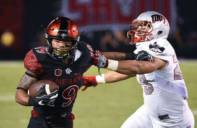 San Diego State running back Donnel Pumphrey (19) ties to break the tackle of UNLV linebacker Matt Lea (23) during the first half of an NCAA college football game, Saturday, Oct. 8, 2016, in San Diego. (AP Photo/Denis Poroy)