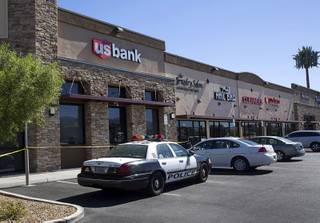 A Metro Police car is shown in front  of a U.S. Bank branch on South Hualapai Way Tuesday, Oct. 11, 2016. Hualapai was closed between Desert Inn Road and Spring Mountain Road after a bank robber left a satchel that he said contained explosives. 