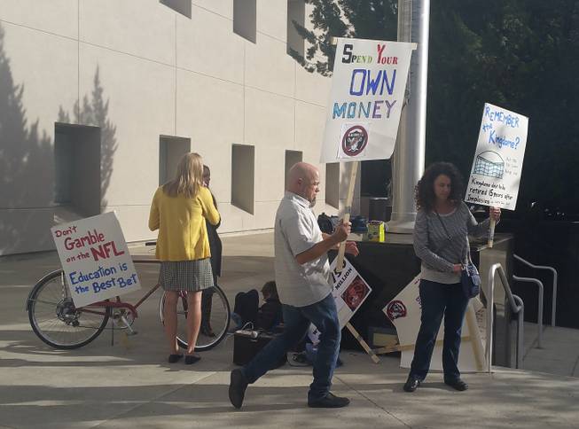 A small group of protesters gather outside the Nevada Capitol building in Carson City on Monday, Oct. 10, 2016. Lawmakers are meeting to vet a public financing plan for a proposed NFL stadium in Las Vegas, but critics say tax money is better used for education.