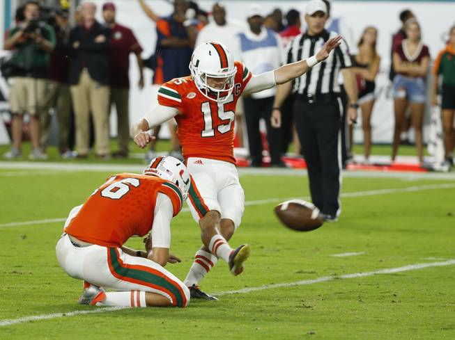 Miami place kicker Michael Badgley (15) hits a field goal as Miami punter Justin Vogel (16) holds, during the second half of an NCAA college football game against Florida State, Saturday, Oct. 8, 2016, in Miami Gardens. The kick was blocked.  