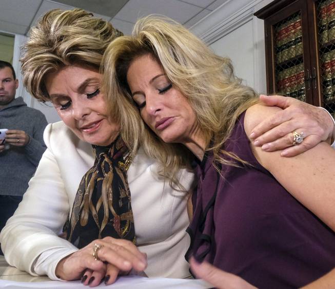 Attorney Gloria Allred, left, comforts Summer Zervos during a news conference in Los Angeles, Friday Oct. 14, 2016. Zervos, a former contestant on "The Apprentice" says Republican presidential candidate Donald Trump made unwanted sexual contact with her at a Beverly Hills hotel in 2007. Zervos is among several women who have made sexual allegations against the Republican nominee. He has strenuously denied them.