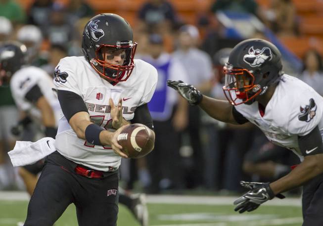 UNLV quarterback Dalton Sneed, left, hands off the football to running back Lexington Thomas, right, during the first quarter of an NCAA college football game against Hawaii, Saturday, Oct. 15, 2016, in Honolulu. 