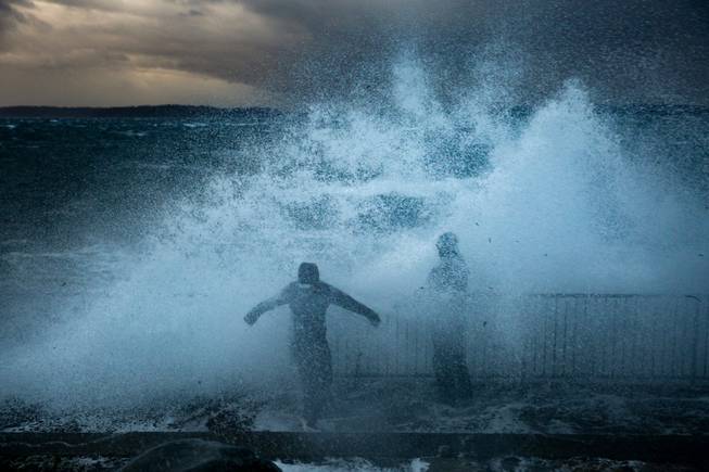 Thrill seekers stand on Charles Richey Sr. Viewpoint in West Seattle as the remnants of Typhoon Songda hit western Washington on Saturday.