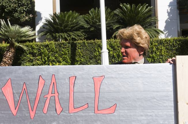 A protester made up as Republican Presidential candidate Donald Trump stands by a makeshift "Trump Wall" during a "Taco-Truck-Wall" Culinary Union Local 226 protest at Trump International, Wednesday, Oct. 19, 2016.