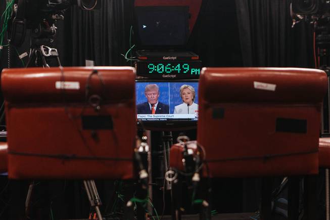 Members of the media watch a tv broadcasting the third presidential debate inside the spin room at Thomas and Mack Center in Las Vegas, Nev. on Oct. 17, 2016.