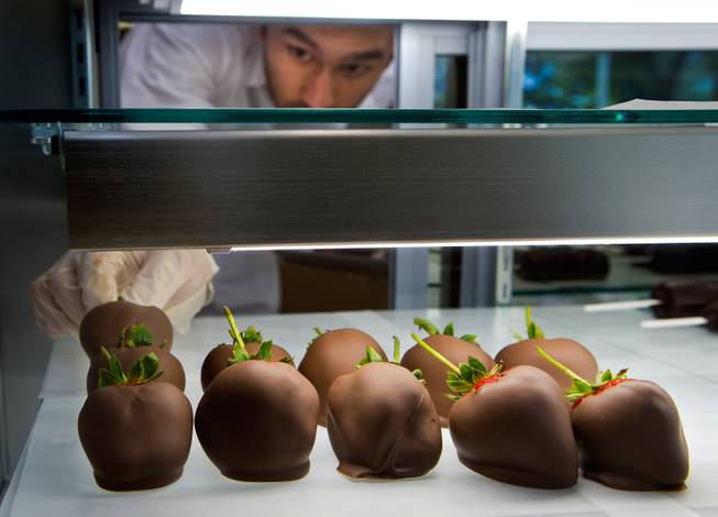 Chief chocolatier Mark Mackey arranges freshly-dipped strawberries at the Ethel M Chocolates store is newly renovated and features more open viewing for customers on Thursday, Oct. 20, 2016.
