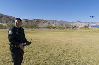 Nevada Highway Patrol Trooper Daniel Marek gives a demo of an unmanned aircraft vehicle (UAV) during the unveiling of Nevada Highway Patrol's new UAV program at Lone Mountain Regional Park in Las Vegas, Friday, Oct. 21, 2016. Trooper Marek is the only trained and authorized operator of the UAV seen in the background.