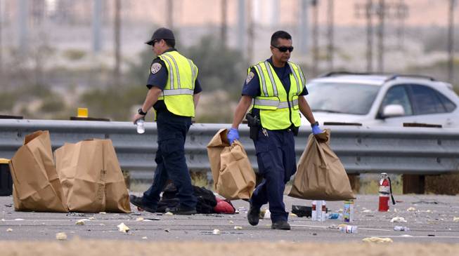 California Highway Patrol officers pick up items in bags after a tour bus crashed with a semi-truck on Interstate 10, west of the Indian Canyon Drive off-ramp, in Desert Hot Springs, near Palm Springs, Calif., Sunday, Oct. 23, 2016. The tour bus and the semi-truck crashed on the highway in Southern California early Sunday, killing at least a dozen of people and injuring at least 30 others, some critically, the California Highway Patrol said.